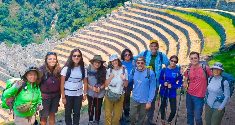 Een groep toeristen met wandeluitrusting poseerde voor oude terrasvormige structuren.