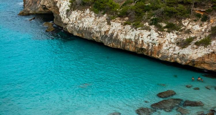 A cove with turquoise water and rocky cliffs.