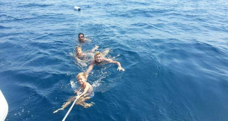 Menschen die genieten van zwemmen in de zee, vastgehouden aan een touw.