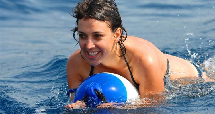 A woman swimming and smiling in the sea.