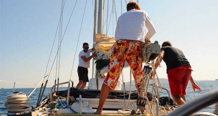 People preparing a sailboat for sailing.