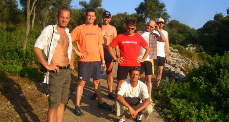 Un grupo de hombres posando para una foto en un sendero con vegetación.