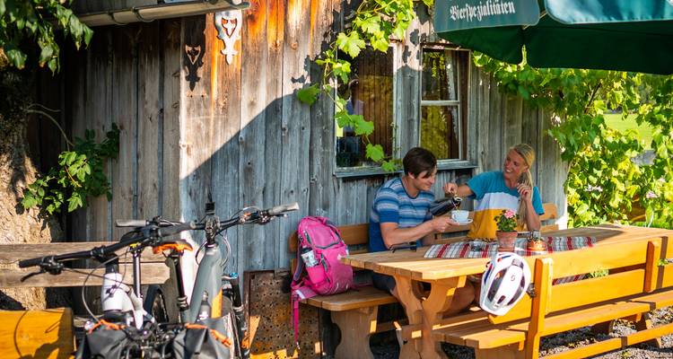 Couple dînant en plein air près d'une cabane rustique.