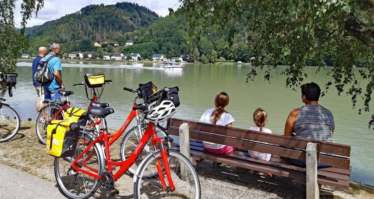 Familie genießt die Aussicht an einem Fluss mit Booten.