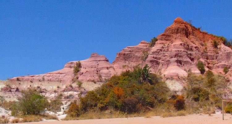 Kleurrijke rotsformaties onder een heldere blauwe hemel.