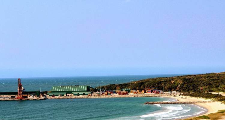 Industriegebied aan de kust met gebouwen en de oceaan.