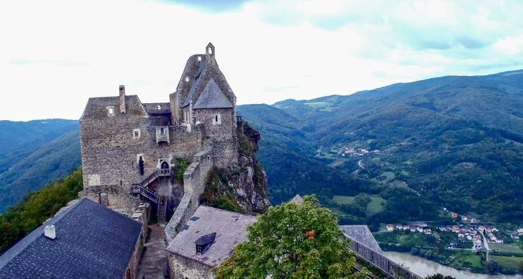 Bergschlosss mit Blick auf ein Tal und einen Fluss.