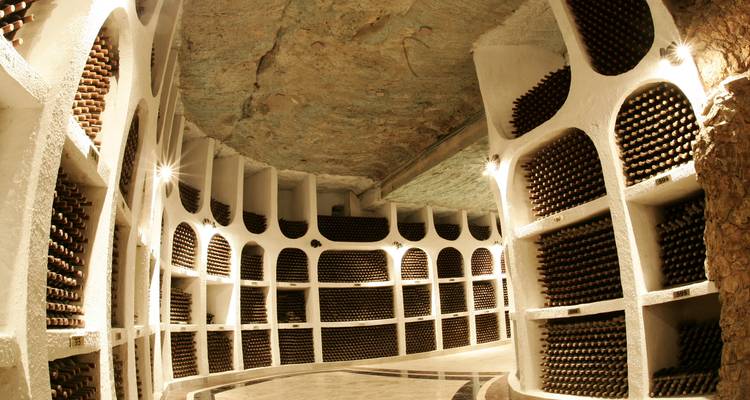 Eindeloze wijnrekken staan in een ondergrondse kalksteenkelder tunnel in wijnmakerij Cricova.