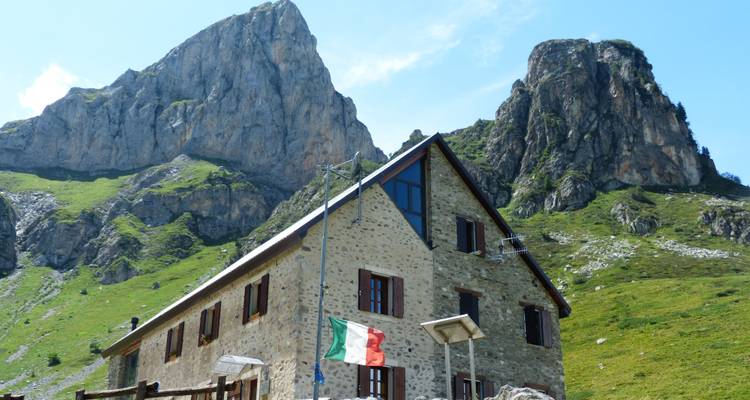 Stenen gebouw in een bergachtig gebied met de Italiaanse vlag.