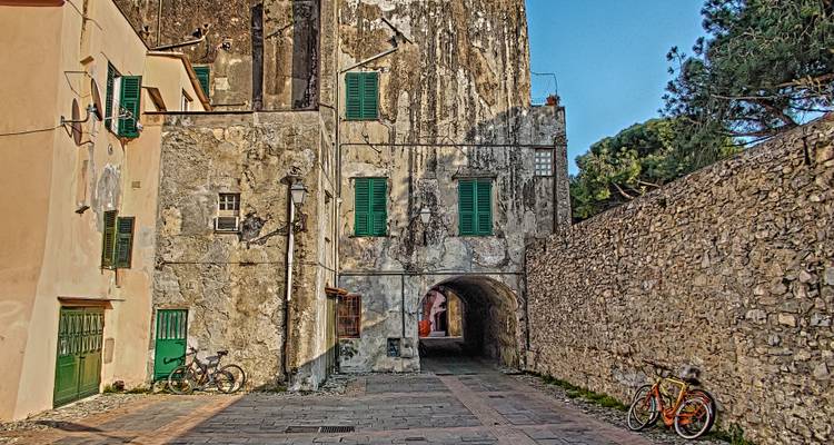 Smalle kinderkopstraat met verweerde gebouwen en fietsen.