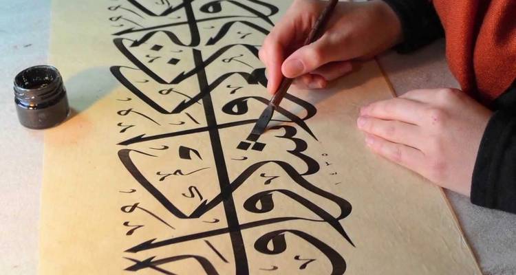 Personne créant de la calligraphie sur un rouleau de papier.