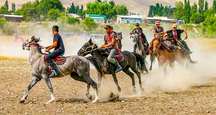 Cavaliers faisant la course dans un champ avec de la poussière qui se soulève.