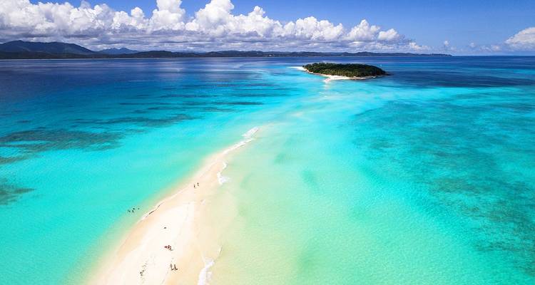 Luchtfoto van een tropisch eiland en zandbank in turquoise wateren.
