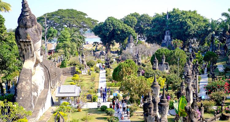 Garden with large stone sculptures overlooking a river.