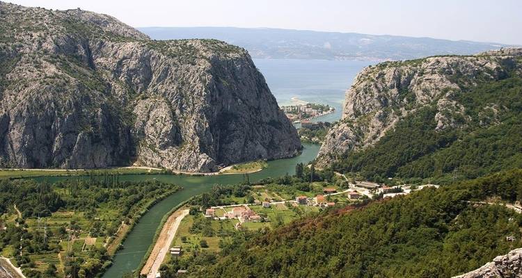 Canyon avec une rivière sinueuse menant à la mer