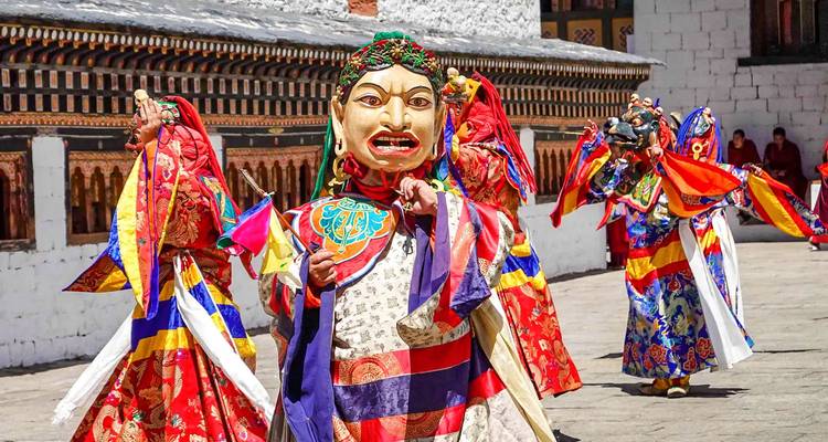 Traditionele Bhutanese dansers in kleurrijke kostuums en maskers.