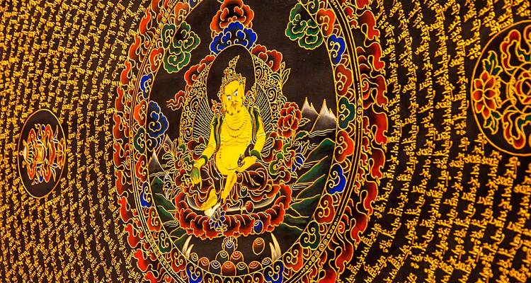 Arte mural circular con patrones dorados intrincados y una figura central.