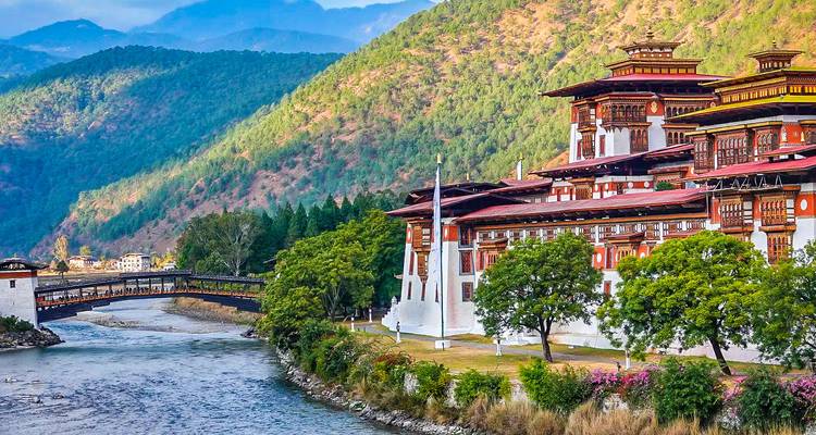Punakha Dzong neben einem Fluss mit bunten Bäumen.