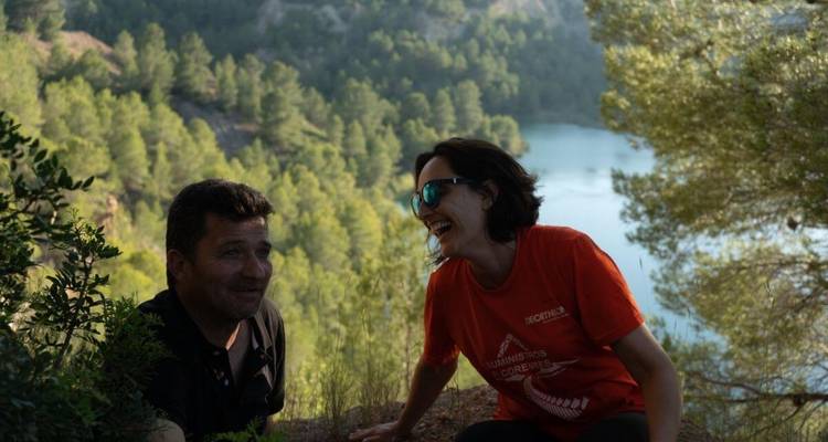 Deux personnes assises sur une colline avec vue sur la forêt.