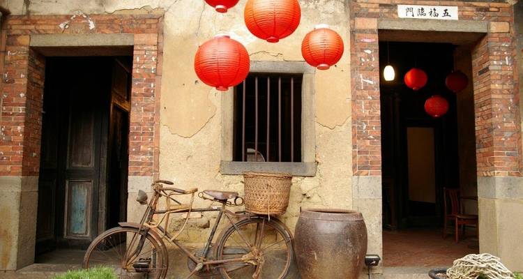 Bâtiment historique avec des lanternes rouges et un vélo vintage.
