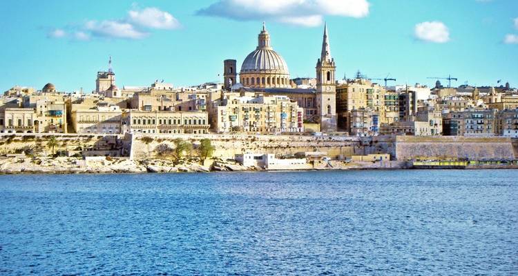 Panoramic view of a historic city skyline with domed buildings.