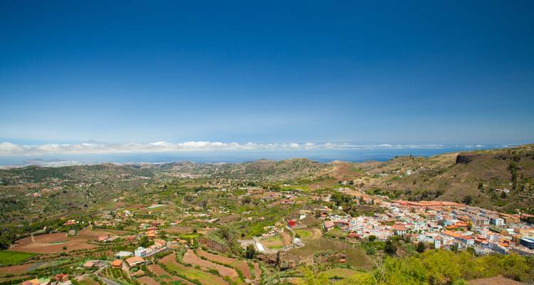 Vue panoramique étendue sur les vallées verdoyantes et l'océan lointain depuis un point de vue élevé par une journée claire