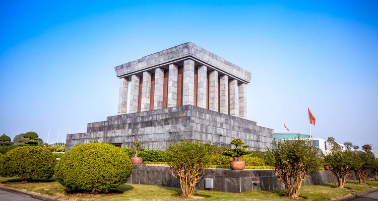 De buitenkant van een monumentaal mausoleum gebouw onder een heldere blauwe lucht.