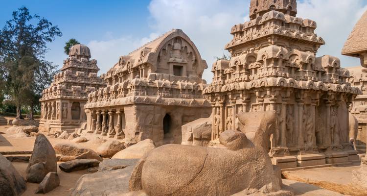 Monolithic stone temples of the Five Rathas complex amid sandy terrain.