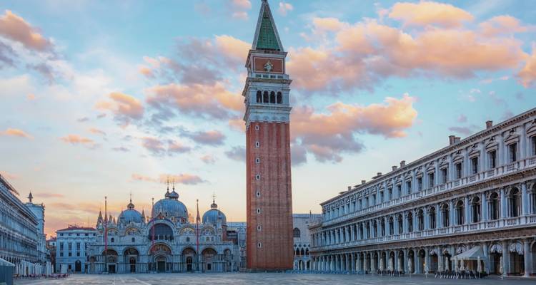 Leerer Markusplatz mit Campanile und Basilika bei Sonnenaufgang unter pastellfarbenen Wolken