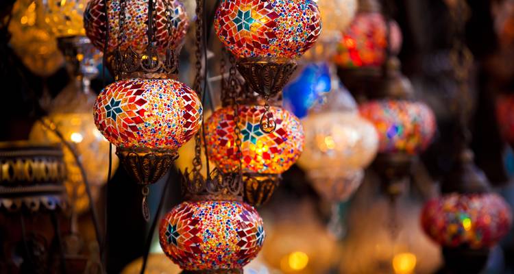 Bunte Mosaiklampen, die in einer Marktumgebung hängen.