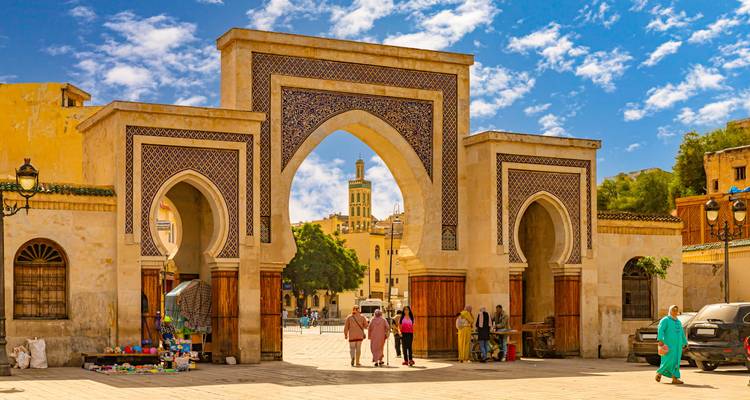 Ancient city gate with people walking through.
