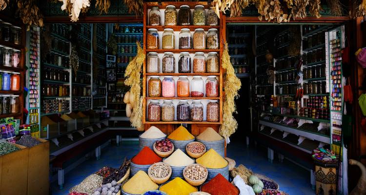 Spice shop with various spices and herbs displayed in jars and sacks.