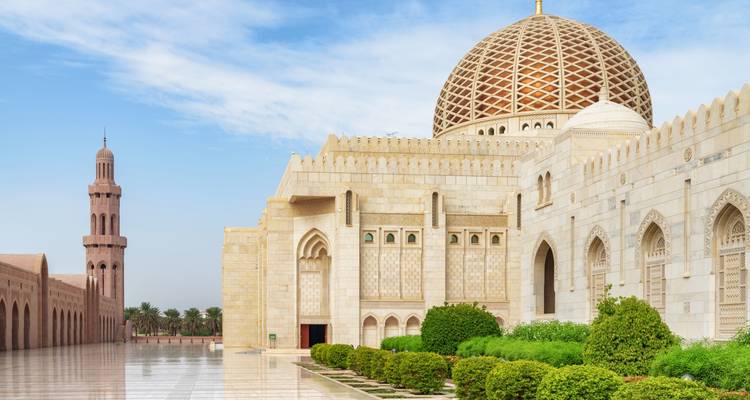 Grand mosque with intricate architecture and a domed roof.