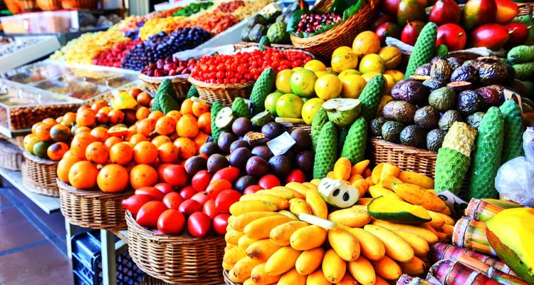 Exposition colorée de fruits exotiques dans des paniers à un étal du marché intérieur.