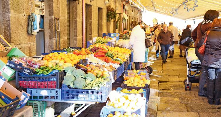 Marché en plein air avec des produits frais et des gens qui font leurs courses.