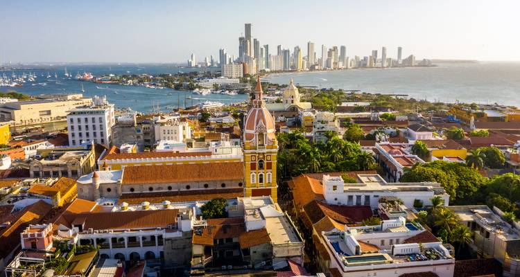 Luchtfoto van Cartagena's historische centrum met kleurrijke koloniale gebouwen die contrasteren met de moderne skyline en de Caribische Zee.