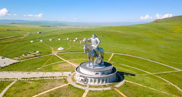 Eine kolossale silberne Reiterstatue von Dschingis Khan steht auf einem kreisförmigen Sockel inmitten der hügeligen grünen Steppe
