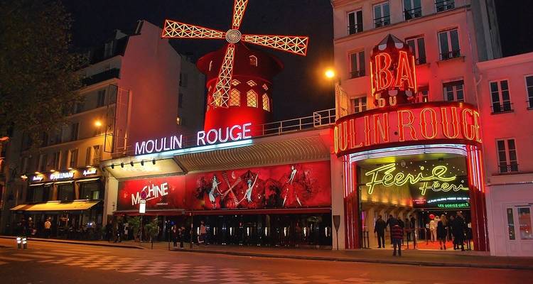 Moulin Rouge avec des néons qui brillent la nuit à Paris.