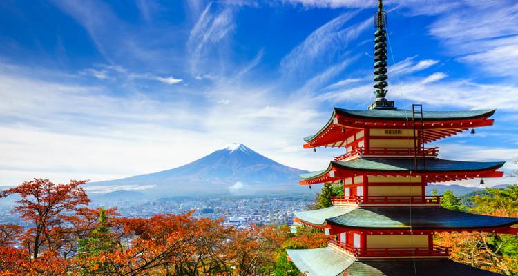 Pagoda Roja Chureito con vista al Monte Fuji y follaje otoñal bajo un cielo azul vívido.
