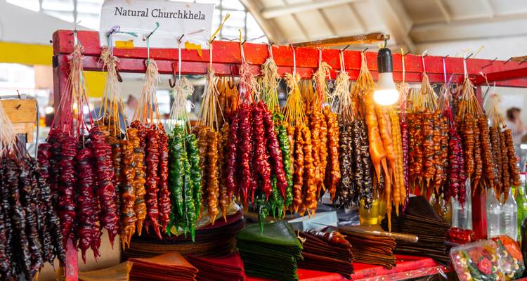 Farbenfrohe Auslage von natürlichen Churchkhela-Süßigkeiten, die in einem lebendigen georgischen Marktstand hängen.