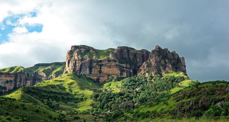 Majestätische Bergkette bedeckt mit üppigem Grün und dramatischen Klippen.