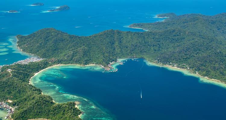 Aerial view of emerald islands and deep blue lagoon fringed by coral reefs