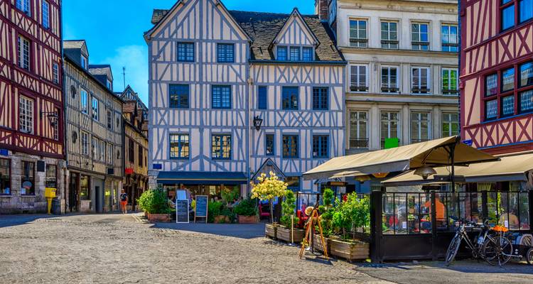 Colorful half-timbered houses lining a lively square in Rouen old town