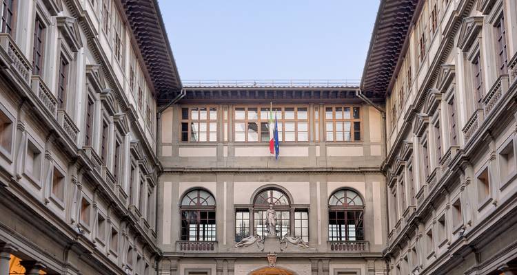 Innenhof der Uffizi-Galerie im Renaissance-Stil, eingerahmt von symmetrischen Steinfassaden und klarem Himmel.