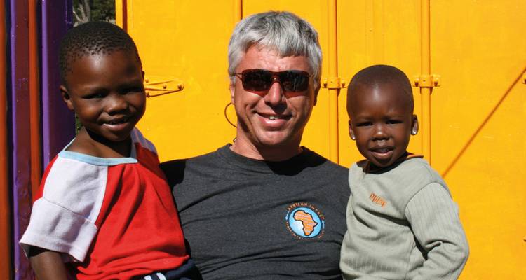 Man with two children smiling and posing outdoors