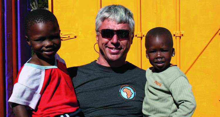 A man with two children smiling at the camera.