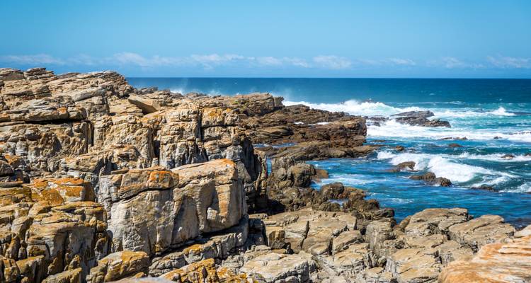 Costa rocosa con olas estrellándose contra rocas escarpadas.