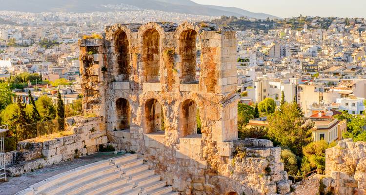 Antike Steintheaterruine mit Blick auf die weitläufige Stadt Athen mit Hügeln im Hintergrund