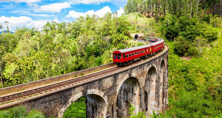 Tren rojo cruzando el famoso Puente de los Nueve Arcos en medio de una exuberante selva en Sri Lanka