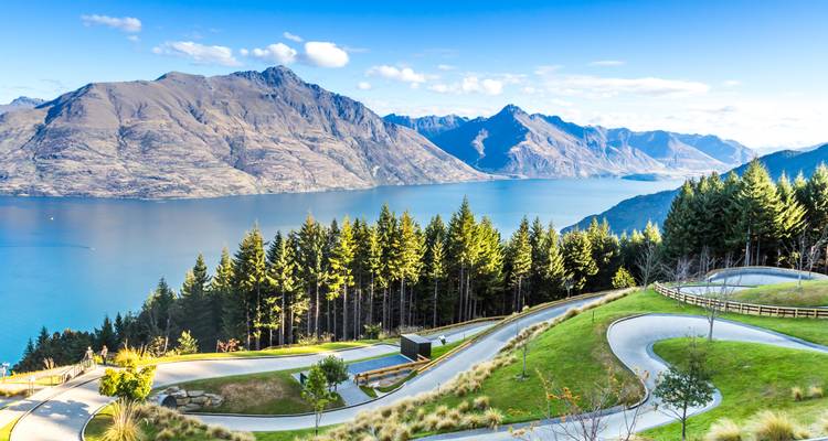 Seeblick mit Bergen und Grün im Hintergrund.